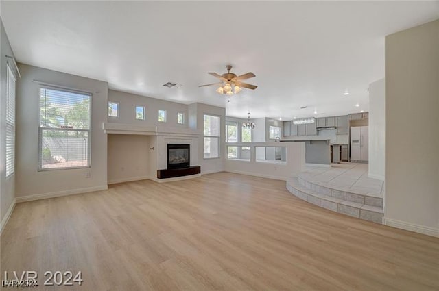 unfurnished living room with light hardwood / wood-style flooring, plenty of natural light, and ceiling fan