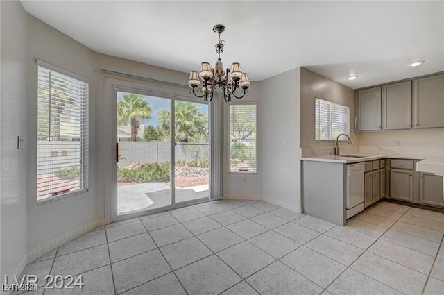 kitchen with dishwasher, light tile patterned floors, a chandelier, and a healthy amount of sunlight