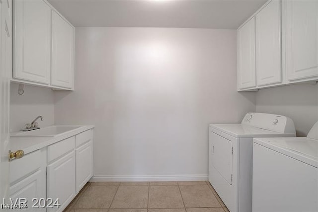 laundry area with cabinets, sink, light tile patterned flooring, and washer and dryer