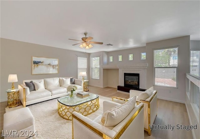 living room with light hardwood / wood-style flooring, a wealth of natural light, and ceiling fan