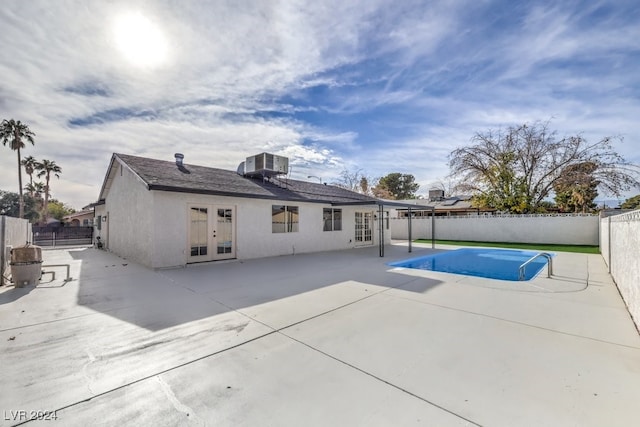 view of swimming pool featuring a patio area, french doors, and central AC unit