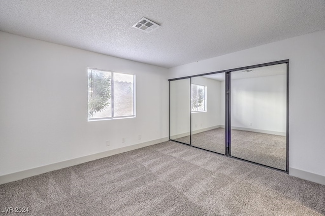 unfurnished bedroom featuring a closet, carpet floors, and multiple windows