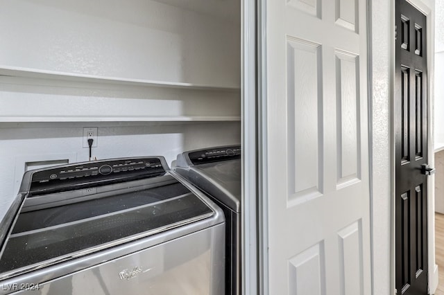 laundry room with washer and dryer and wood-type flooring