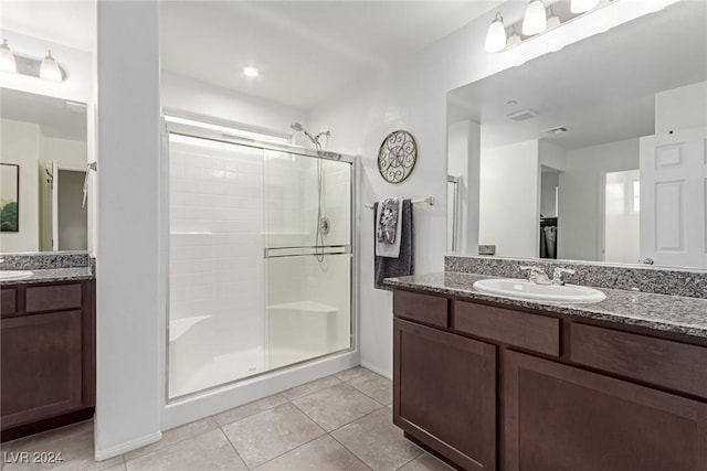 bathroom featuring a shower with door, vanity, and tile patterned flooring