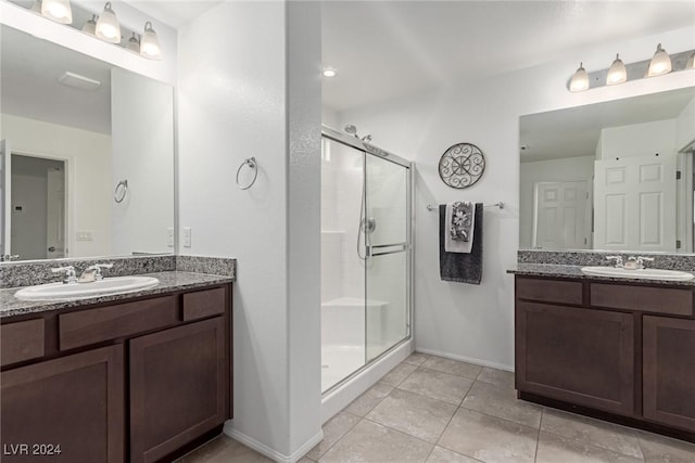 bathroom featuring tile patterned floors, vanity, and a shower with door