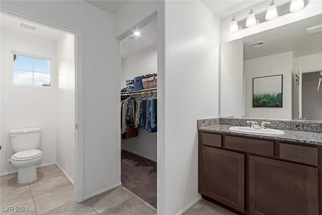 bathroom featuring tile patterned floors, vanity, and toilet