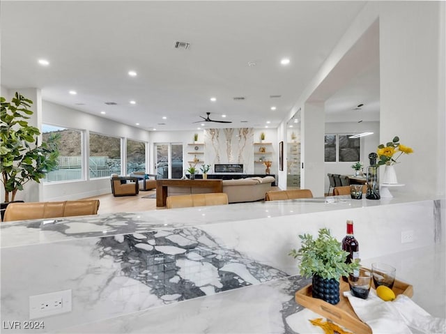 interior space featuring ceiling fan and a fireplace