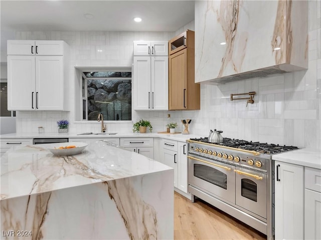 kitchen with light stone countertops, sink, decorative backsplash, white cabinets, and appliances with stainless steel finishes