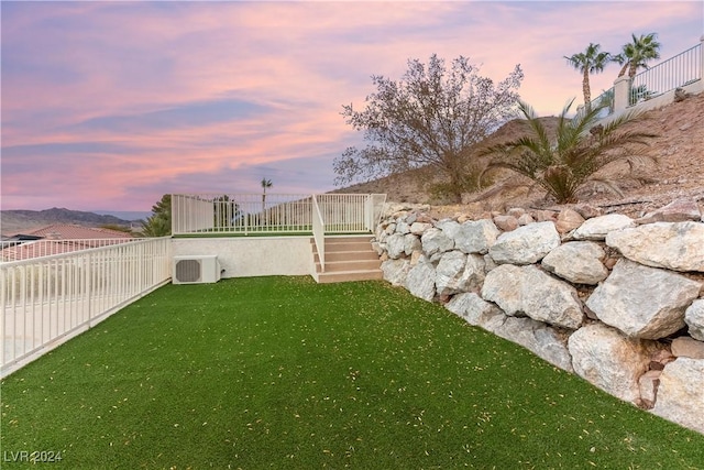 yard at dusk with a mountain view and cooling unit