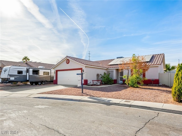 view of front of home featuring a garage and solar panels