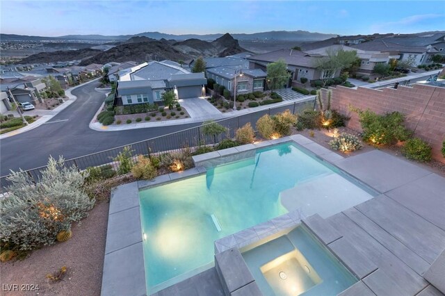 view of swimming pool with an in ground hot tub and a mountain view