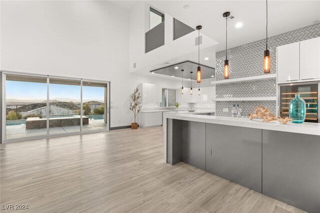 kitchen featuring pendant lighting, white cabinets, light hardwood / wood-style floors, a mountain view, and fridge