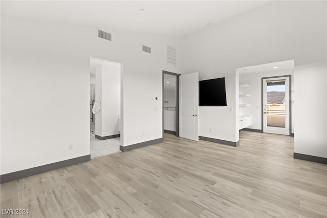 unfurnished room featuring light hardwood / wood-style floors and high vaulted ceiling