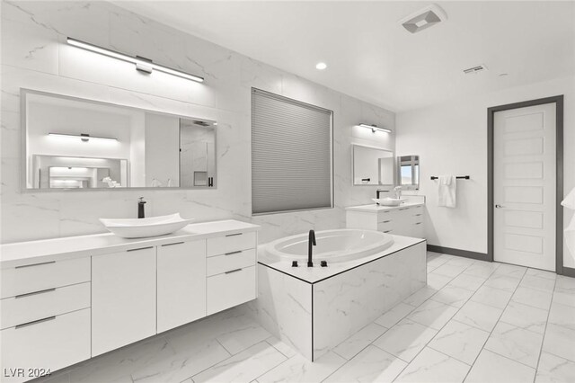 bathroom featuring tiled tub and vanity