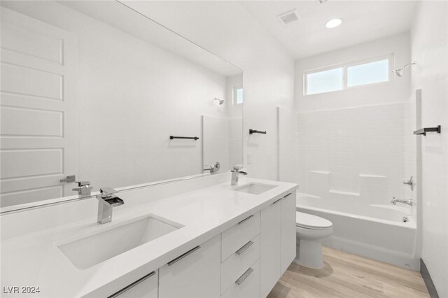 full bathroom with hardwood / wood-style floors, toilet, shower / bathing tub combination, and vanity