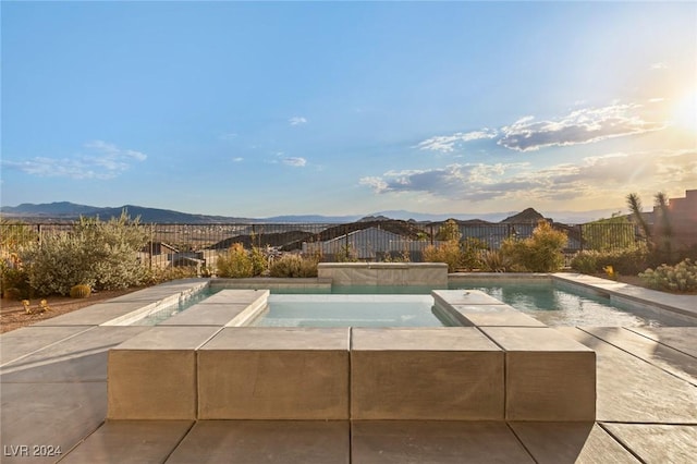 view of pool with an in ground hot tub and a mountain view