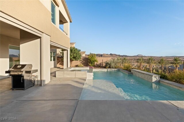 view of pool with a mountain view, a patio area, and area for grilling