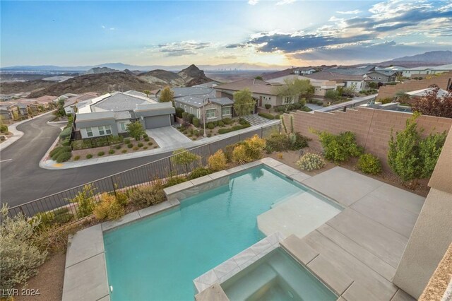 view of swimming pool featuring a mountain view and an in ground hot tub