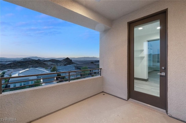 balcony at dusk featuring a mountain view