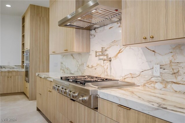 kitchen with light brown cabinets, stainless steel gas cooktop, and range hood