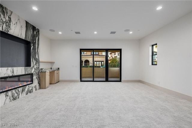 living room featuring a fireplace and light carpet