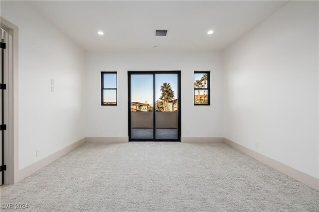 unfurnished room featuring light colored carpet