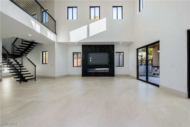 unfurnished living room featuring a high ceiling