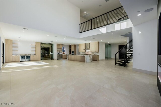 unfurnished living room with a towering ceiling