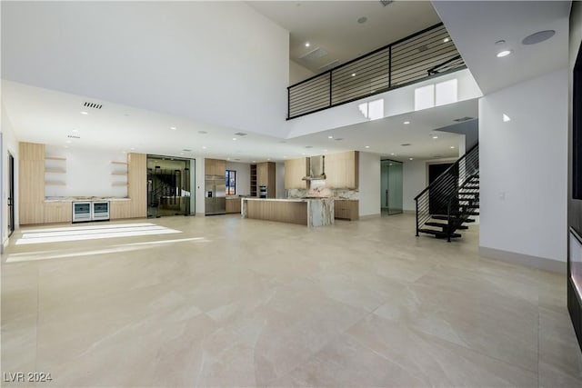 unfurnished living room with a towering ceiling