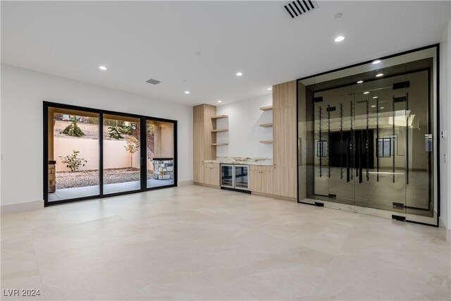 unfurnished living room featuring wine cooler