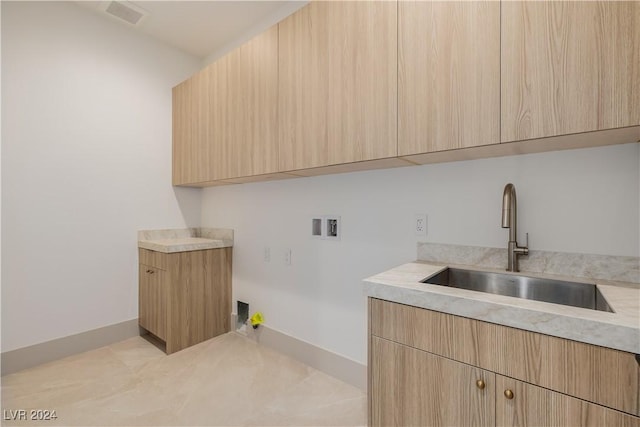 clothes washing area featuring cabinets, sink, and hookup for a washing machine