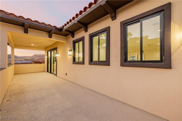 property exterior at dusk featuring a balcony