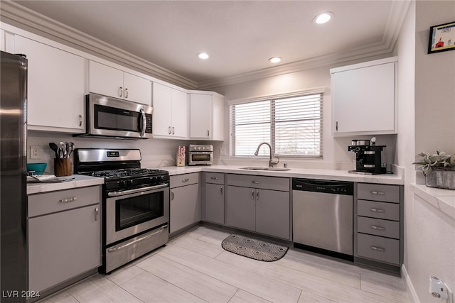 kitchen with white cabinetry, appliances with stainless steel finishes, gray cabinets, and light countertops