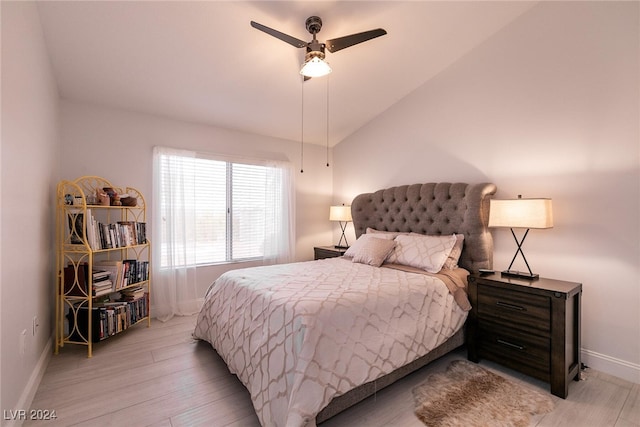 bedroom featuring lofted ceiling, light wood-style flooring, baseboards, and ceiling fan