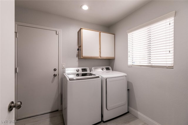 laundry area with baseboards, cabinet space, and washer and dryer