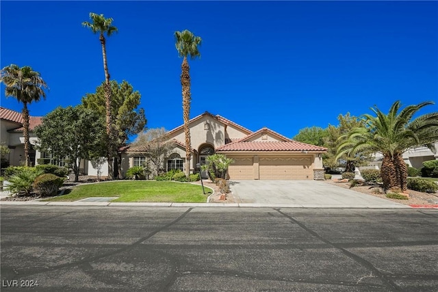 mediterranean / spanish-style house with a garage and a front yard