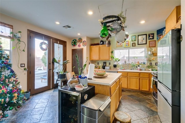 kitchen featuring plenty of natural light, a center island, refrigerator, and french doors