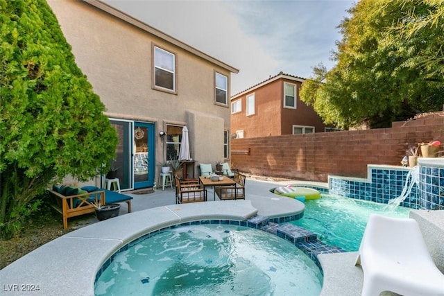 view of swimming pool featuring an in ground hot tub, an outdoor living space, and a patio area