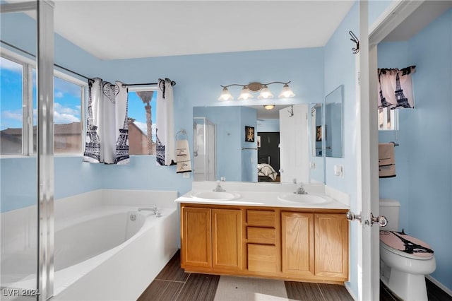 bathroom featuring a washtub, vanity, and toilet