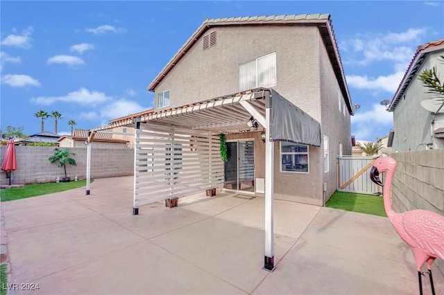 rear view of house featuring a pergola and a patio