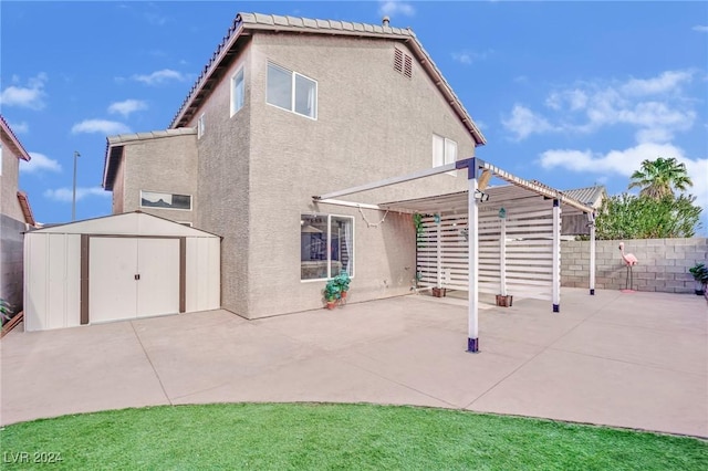 rear view of property featuring a patio area and a storage shed