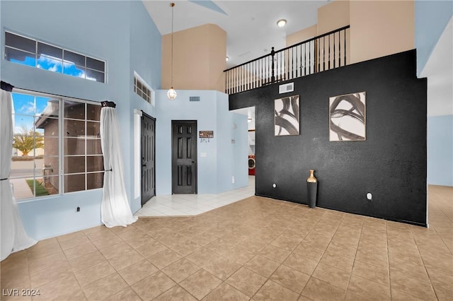 interior space featuring a high ceiling and light tile patterned floors