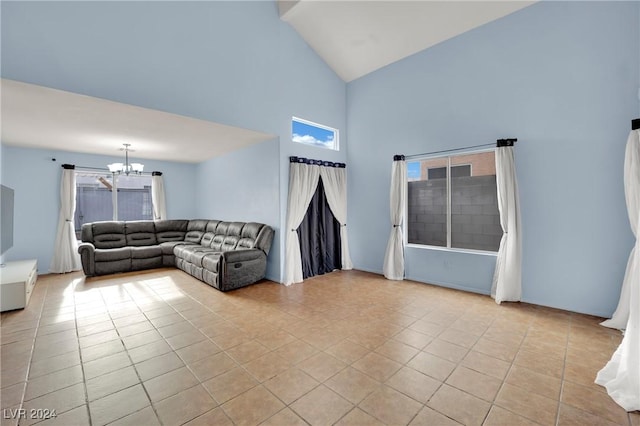 unfurnished living room featuring light tile patterned floors, an inviting chandelier, and high vaulted ceiling