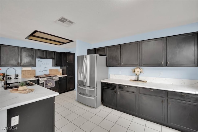 kitchen with light stone countertops, sink, light tile patterned floors, and appliances with stainless steel finishes