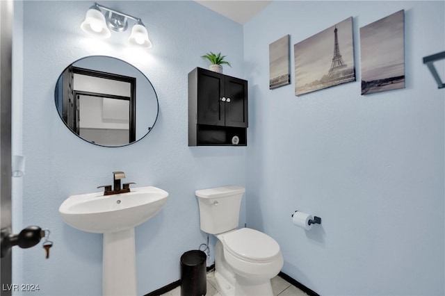 bathroom featuring tile patterned flooring, toilet, and sink