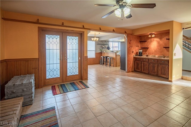 foyer entrance with sink, french doors, ceiling fan with notable chandelier, and light tile patterned flooring