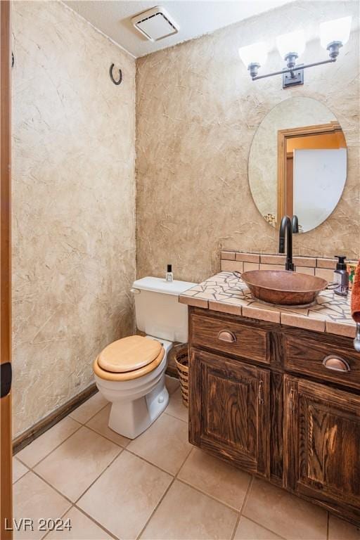 bathroom featuring tile patterned floors, vanity, and toilet