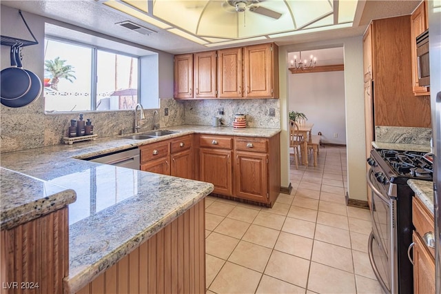 kitchen featuring tasteful backsplash, ceiling fan with notable chandelier, stainless steel appliances, sink, and light tile patterned floors