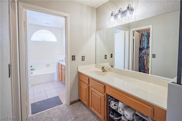 bathroom with tile patterned floors, a bathtub, and vanity