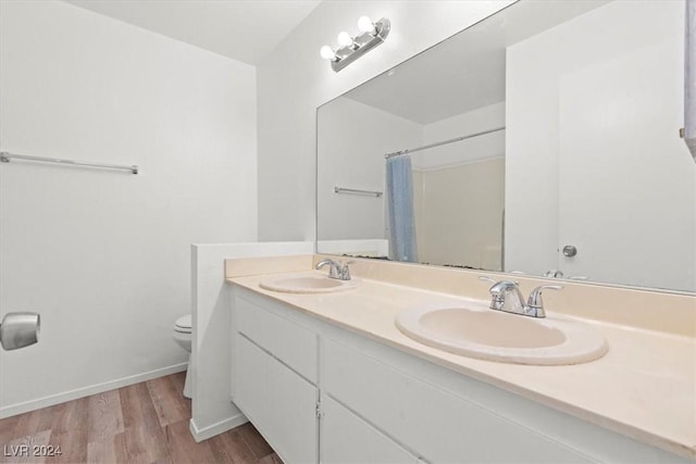 bathroom featuring wood-type flooring, vanity, and toilet